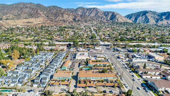 Aerial panoramic view of a residential and commercial area with mountains in the background.