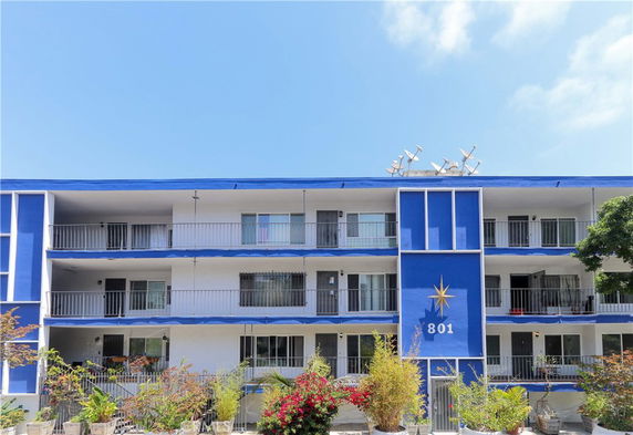 Front view of a three-story apartment building with balconies.