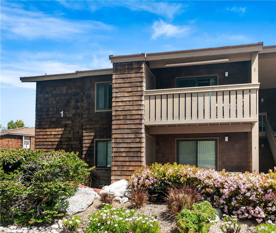 Front view of a two-story residential building with wooden siding and balconies.