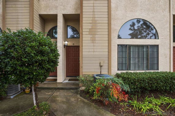 Front view of a townhouse with double doors and large arched windows.