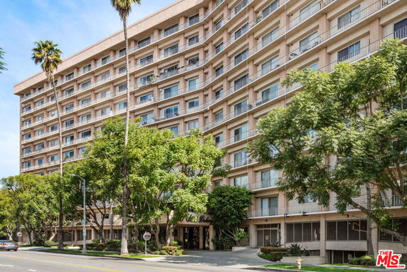 Front view of a multi-story building with numerous balconies.