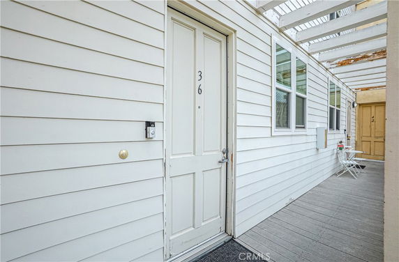 Front view of a white exterior with a door labeled 36, part of a multi-unit building.