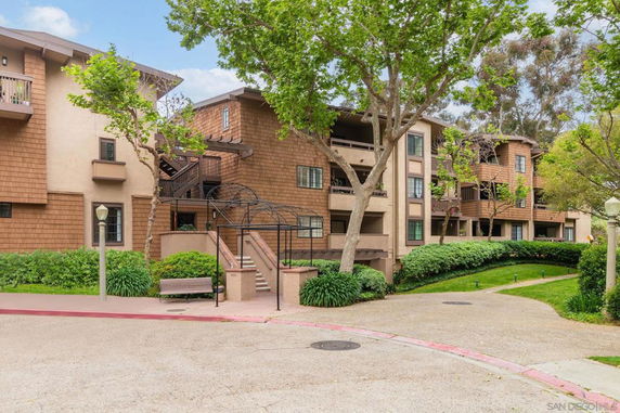 Front view of a multi-story residential building with balconies and a staircase.