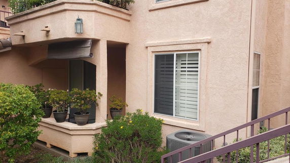 Front view of a multi-story building with a small balcony and windows.