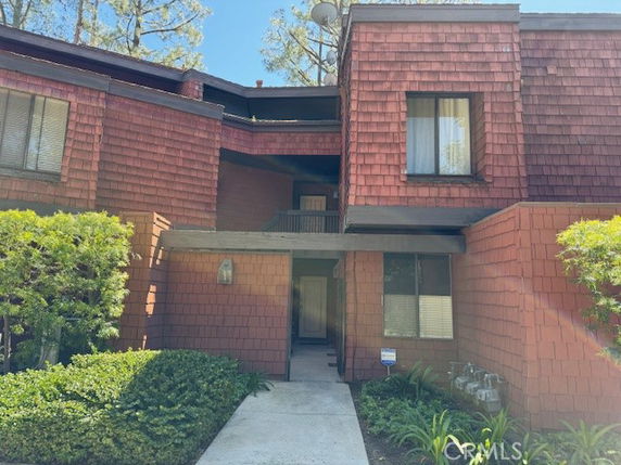 Front view of a multi-story building with wood shingle exterior.