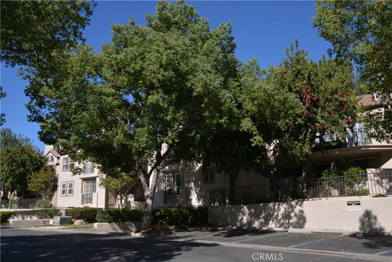 Front view of a multi-story residential building with trees around.