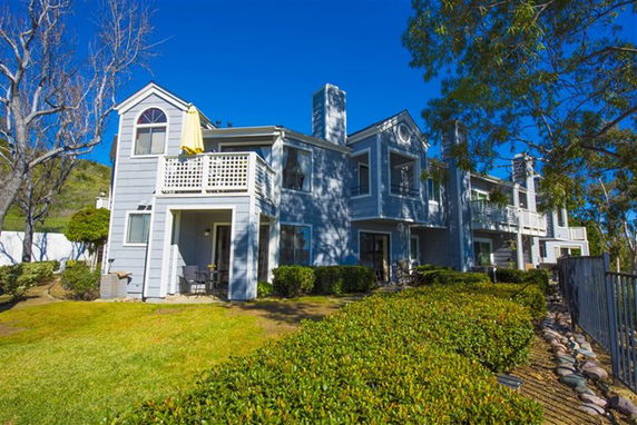 Front view of a two-story residential building with multiple balconies and a chimney.