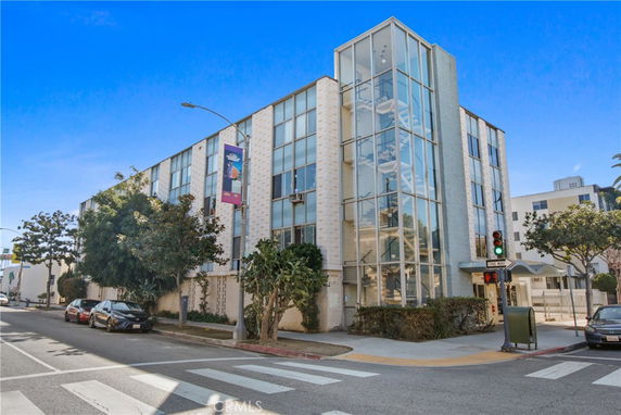 Front view of a multi-story building with large glass panels and an external stairwell.