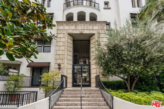 Entrance of a multi-story building with a grand archway and balcony.