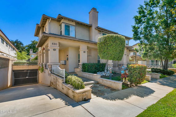 Front view of a two-story house with a gated entrance and driveway.