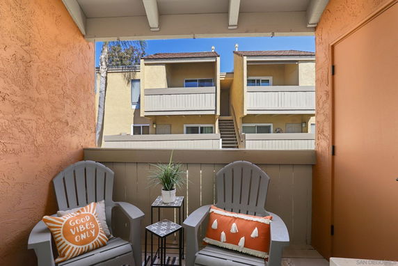 View from a balcony showing an adjacent building with balconies and stairs.