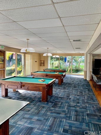 Room with billiards tables in a clubhouse setting.