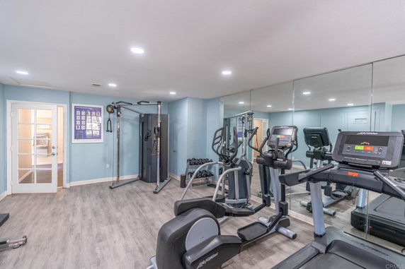 Indoor gym area with exercise equipment and mirrors.