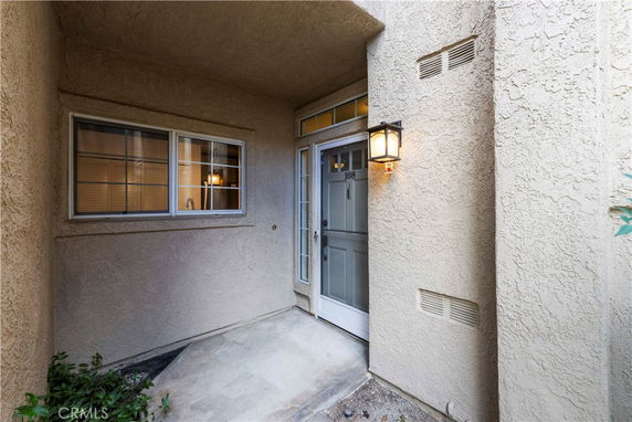 Front view of a house entrance with a porch light and window.