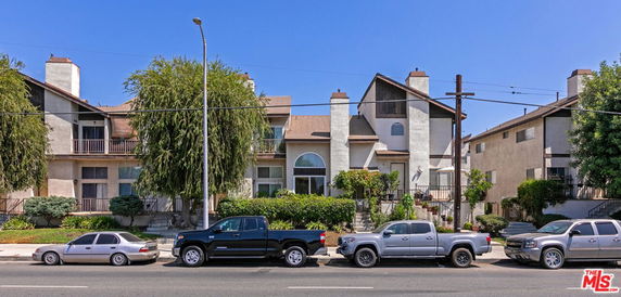 Front view of a multi-story residential building with a contemporary design and multiple chimneys.
