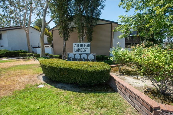 Front view of a residential building with a brown and white facade.