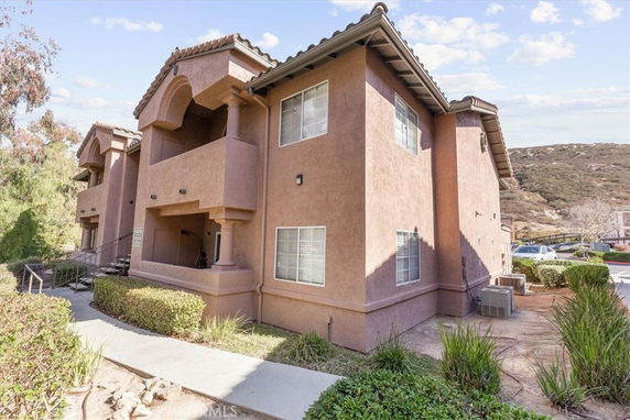 Front view of a two-story apartment building with balconies and tiled roof.
