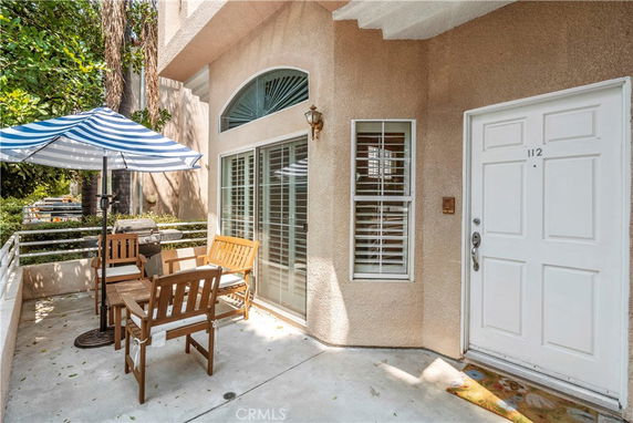 Front view of a house with a patio area and seating.