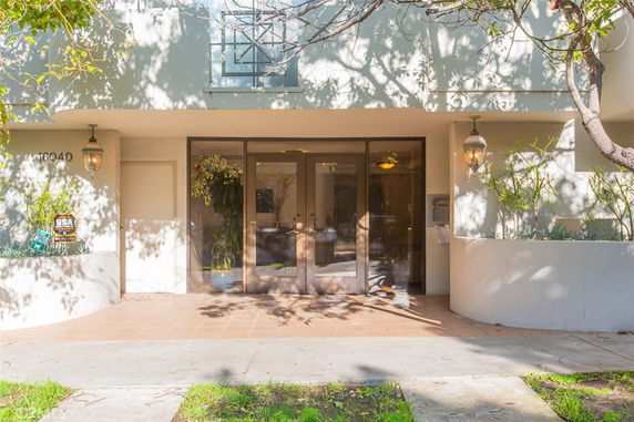 Front view of a building entrance with glass doors and decorative lanterns.
