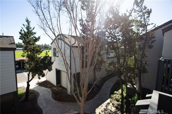 View of the surrounding area near a two-story building with trees and a pathway.