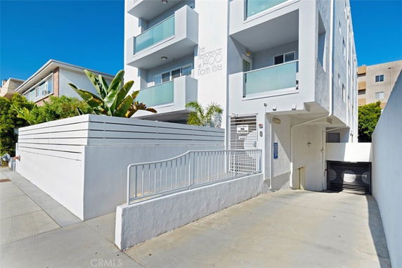 Front view of a modern multi-story apartment building with balconies.