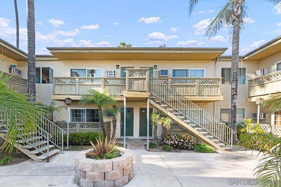 Front view of a two-story apartment building with exterior staircases and balconies.