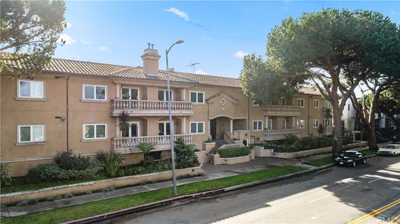 Front view of a two-story residential building with balconies and tiled roof.