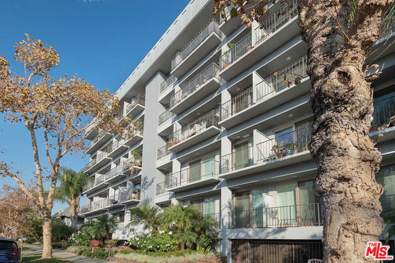 Front view of a multi-story apartment building with balconies.