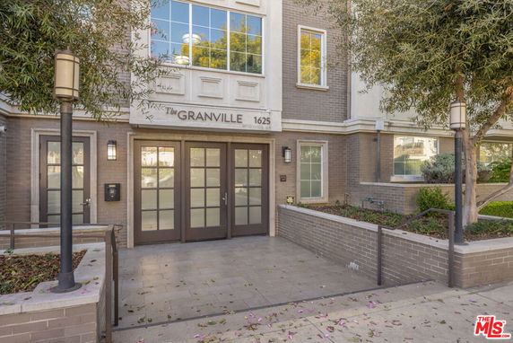 Front view of a multi-story building with glass doors and windows, labeled 'The Granville' above the entrance.