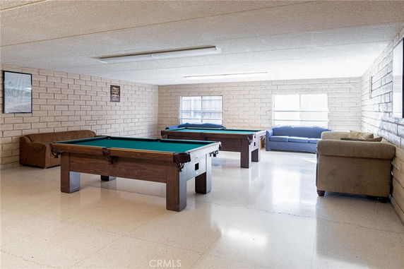 Room with pool tables and seating area.