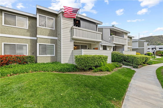 Front view of a multi-story building with balconies and an American flag.