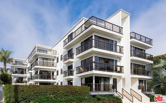 Front view of a multi-story modern apartment building with balconies.