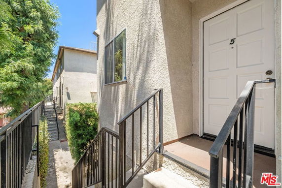 Entryway to an apartment building with a white door and number 5.