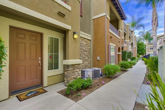 Front view of a multi-story residential building with a walkway.