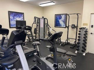 Indoor gym area with exercise equipment and weights.