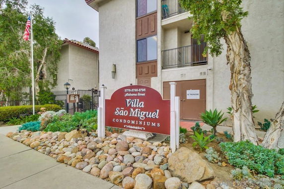 Front view of a condominium building with a sign reading 'Villa São Miguel.'