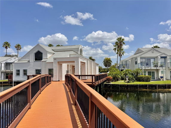 Front view of a waterfront house with a wooden walkway.