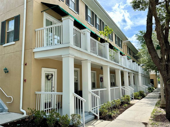 Front view of a multi-story building with balconies and a beige exterior.