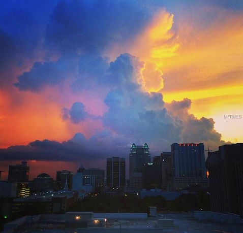 City skyline at sunset with colorful clouds.