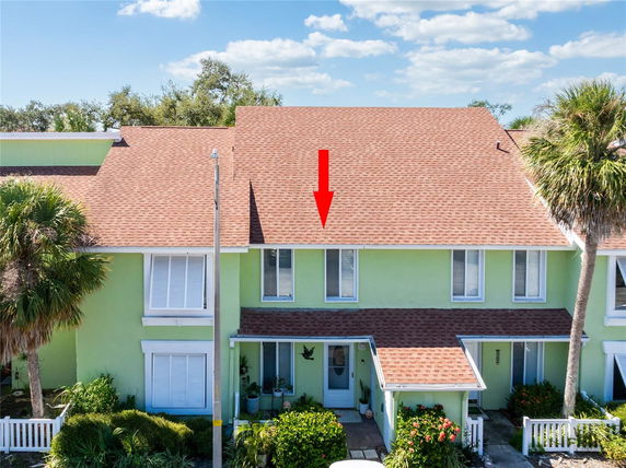 Front view of a two-story house with a gable roof and green exterior walls.
