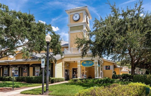 Front view of a building with a clock tower and yellow exterior.