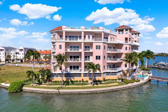 Front view of a multi-story waterside apartment building with balconies.