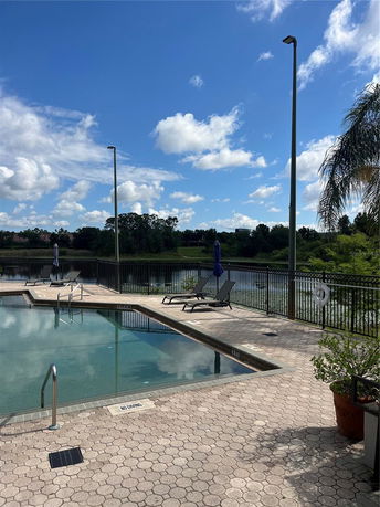 Outdoor swimming pool with lounge chairs and umbrellas around it.