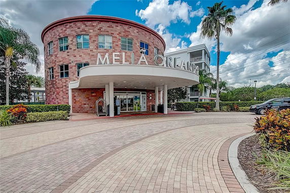 Front view of a building with a circular design and a large entrance canopy.