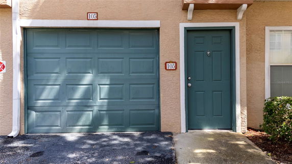Front view of a house with a green garage door and a matching front door.