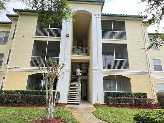 Front view of a multi-story apartment building with balconies.
