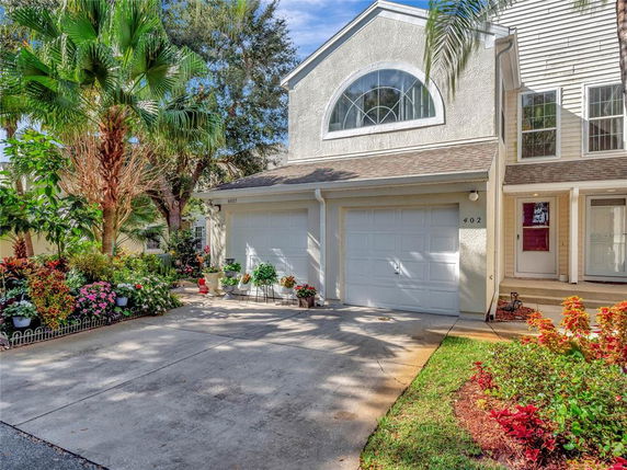 Front view of a townhouse with a double garage and arched window.