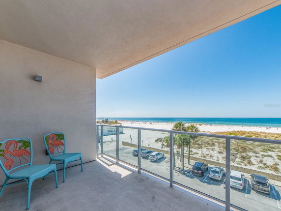 Balcony view overlooking a sandy beach and ocean.