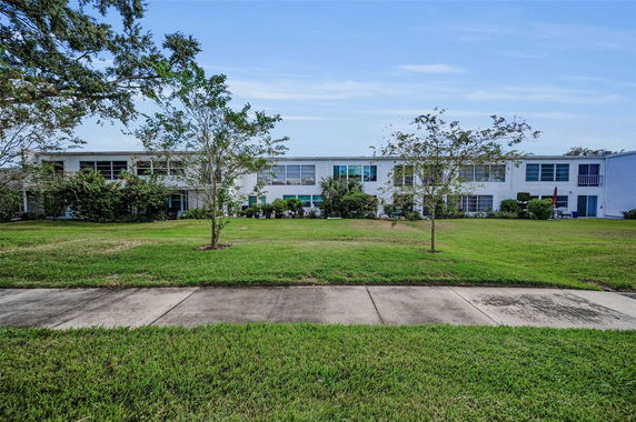 Front view of a two-story building with multiple windows and a landscaped lawn.