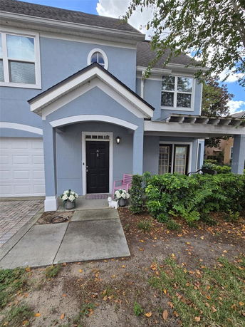 Front view of a two-story house with a garage and entrance porch.